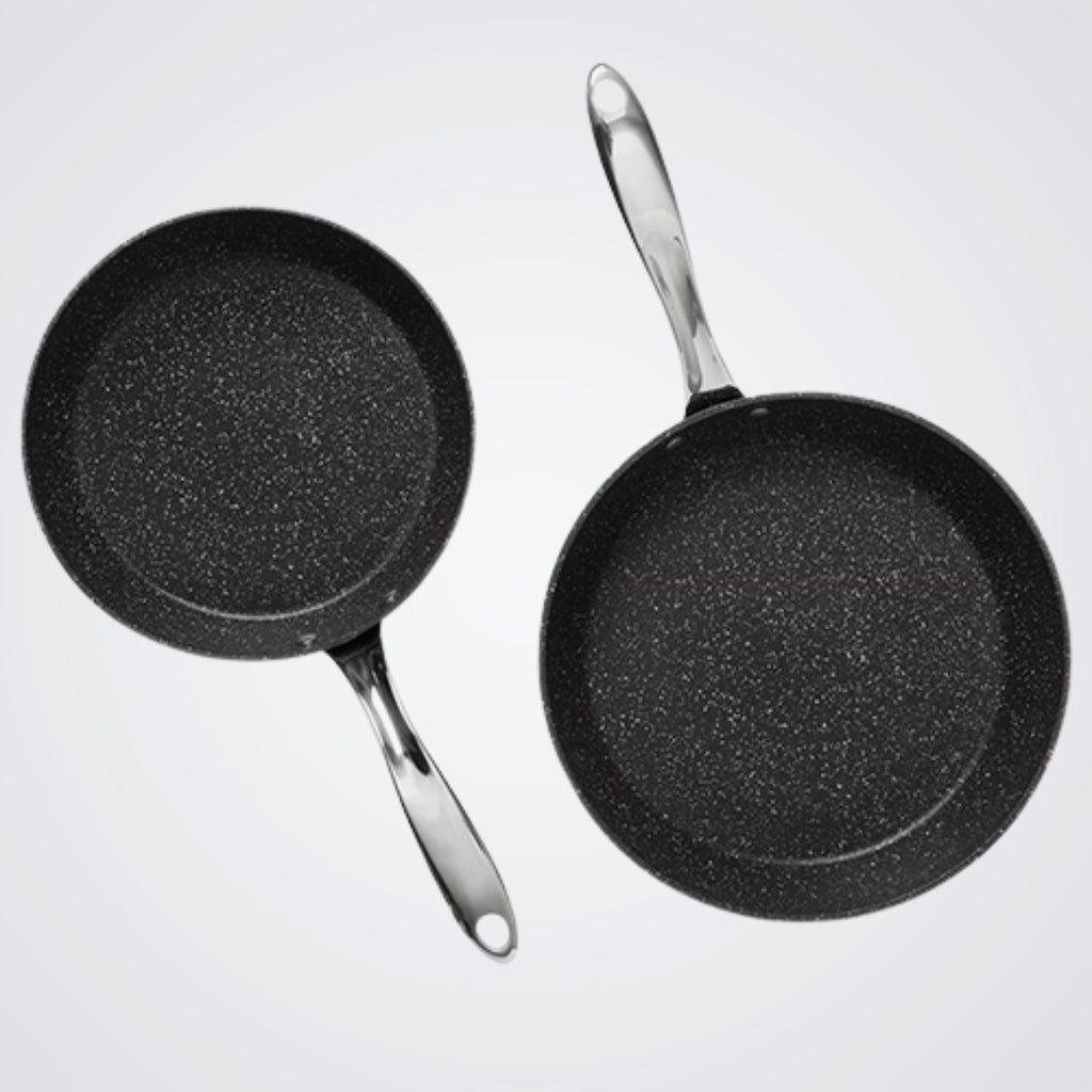 Two Westinghouse black frying pans with speckled texture on a light grey background