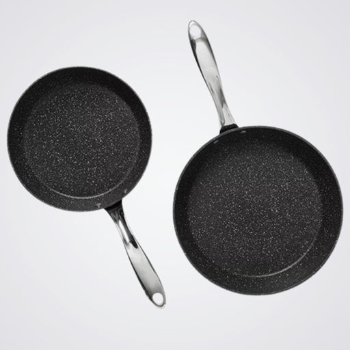 Two Westinghouse black frying pans with speckled texture on a light grey background