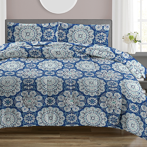 Blue and white patterned bedding set on a bed in a room with a window and plant.