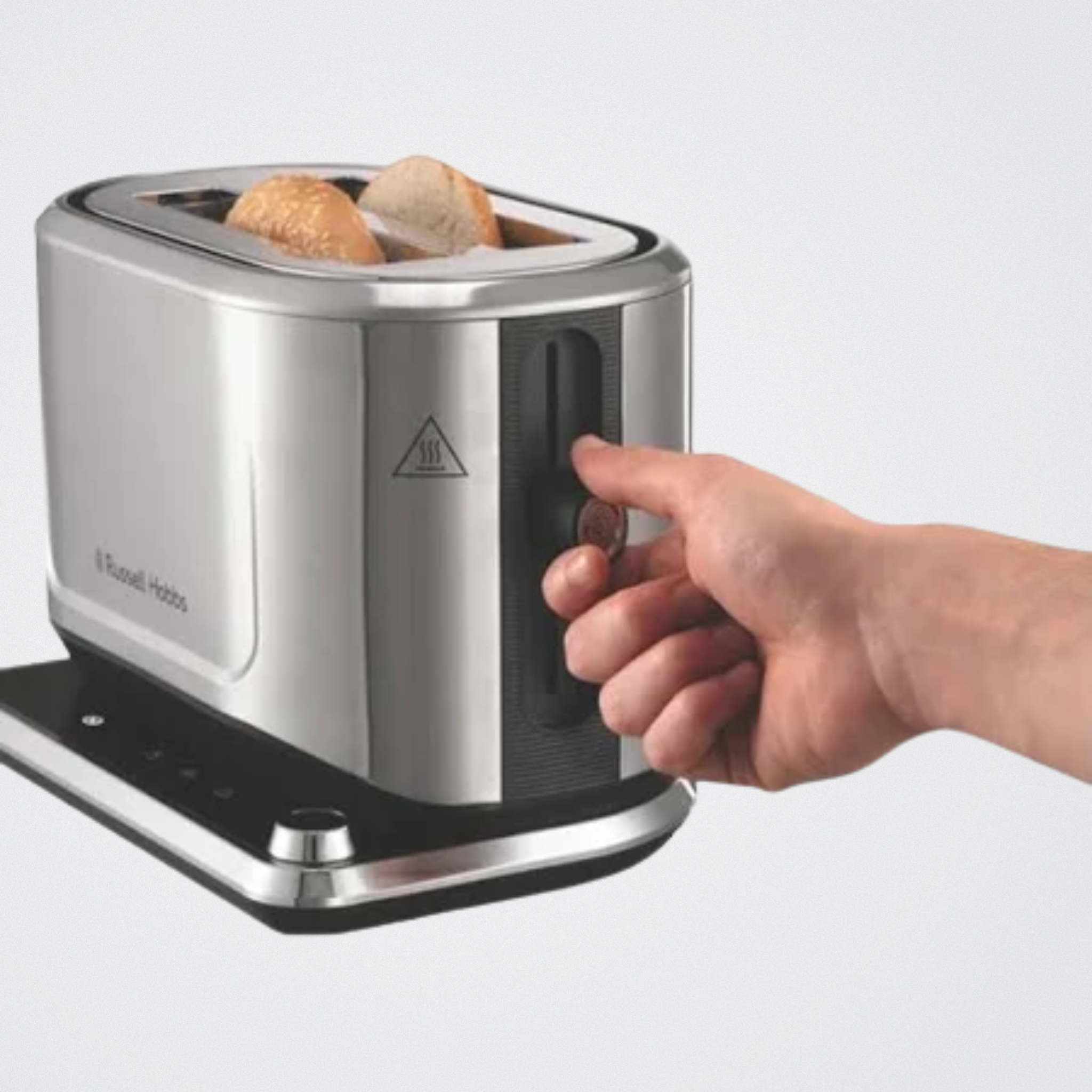 Stainless steel toaster with bread and a hand inserting a Bread.