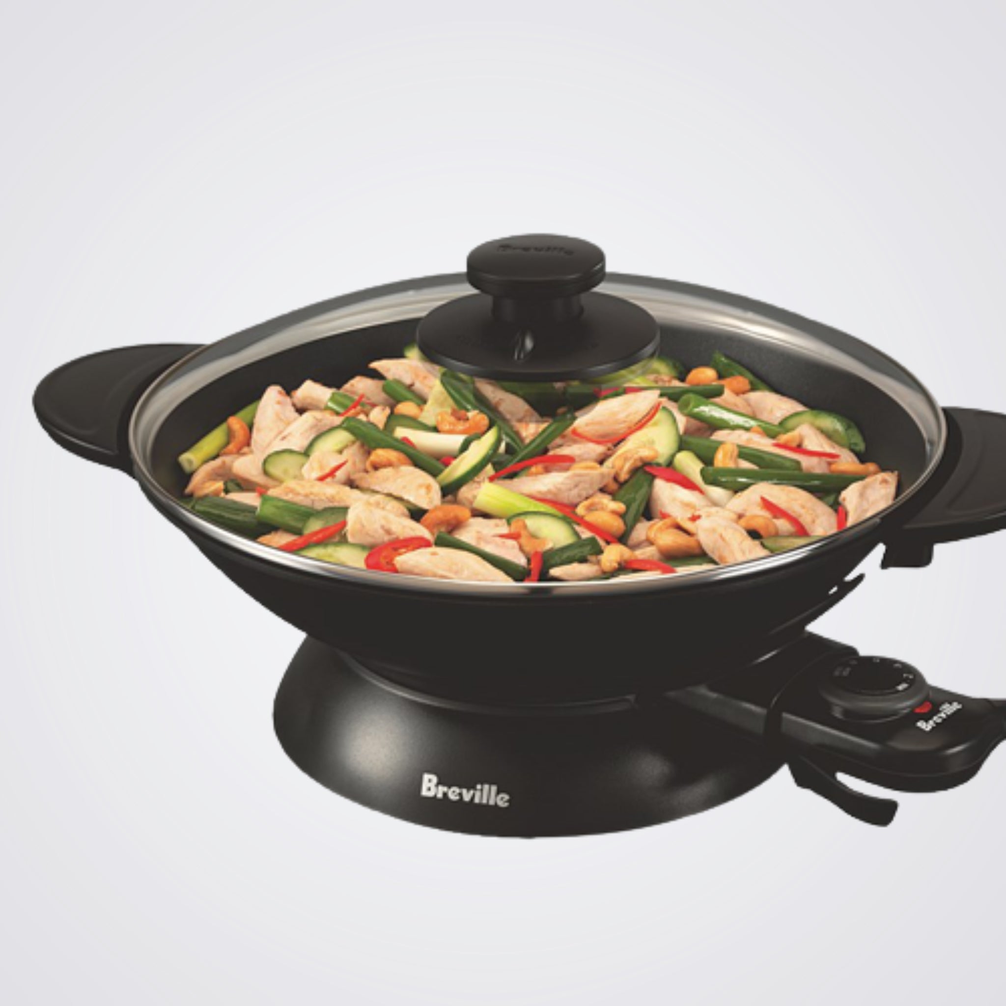Breville electric wok with food inside on a light background