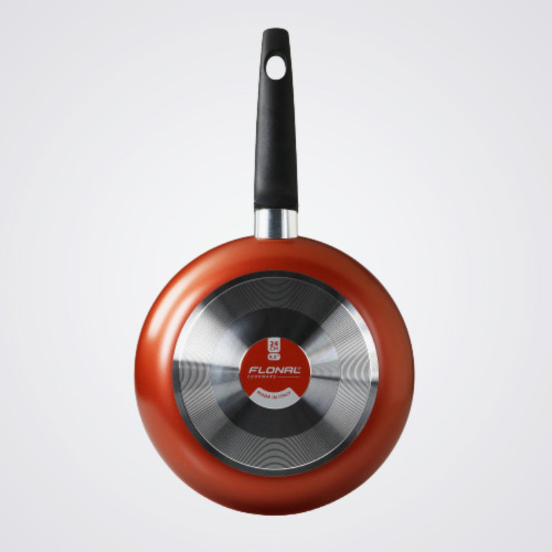 Red frying pan with black handle on a Light background