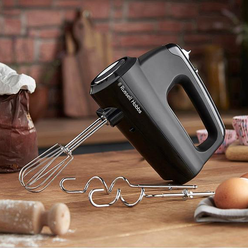 Russell Hobbs Black hand mixer with attachments on a wooden surface, brick wall in the background