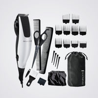 Remington grooming kit with hair trimmer, scissors, combs, and attachments on a light grey background