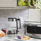 Kitchen counter with a glass coffee maker, toaster, and pastries.