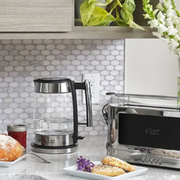 Kitchen counter with a glass coffee maker, toaster, and pastries.
