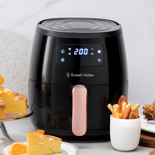 Black Russell Hobbs air fryer with digital display on a kitchen counter with food items.