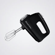 Black hand mixer with whisk attachment on a light grey background